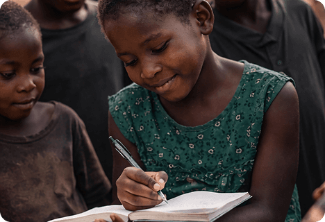 A child writing in a journal at the Ivory Coast refugee camp